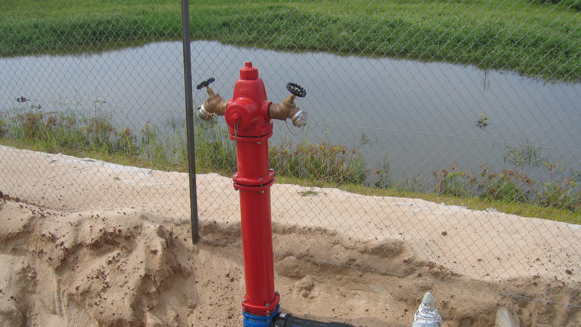 AVK fire hydrant installed in sand by lake