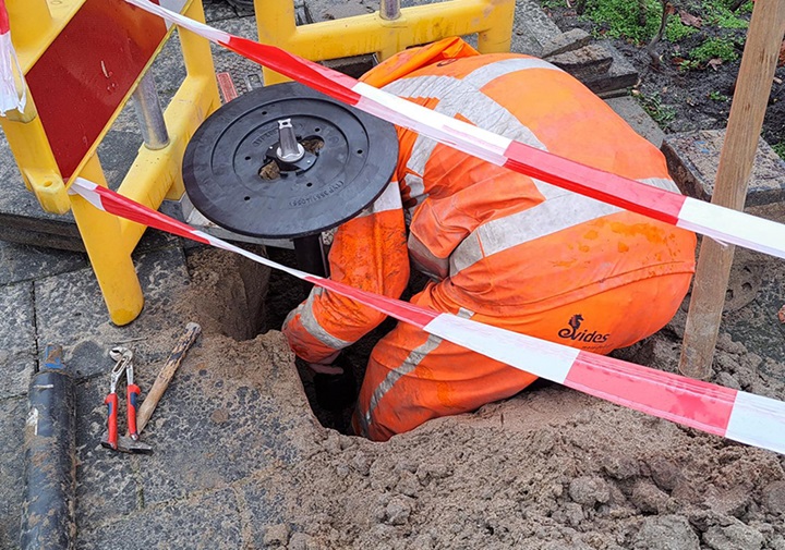 Worker installing vidi positioner for water supply network