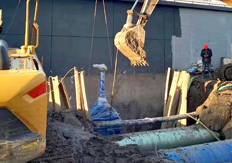 Machines digging and installing a large gate valve