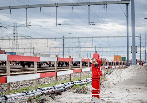 A red AVK fire hydrant next to the railway